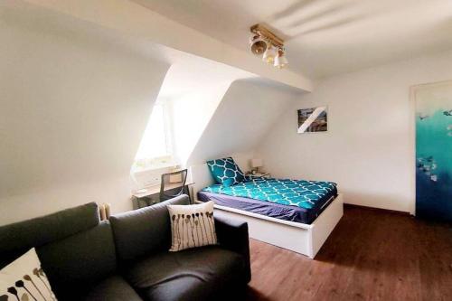 uma sala de estar com uma cama e um sofá em Gemütliches Apartment Nähe DU Zentrum/Uni/Hbf/A40 em Duisburg