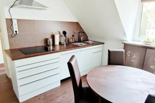 uma pequena cozinha com uma mesa e um lavatório em Gemütliches Apartment Nähe DU Zentrum/Uni/Hbf/A40 em Duisburg
