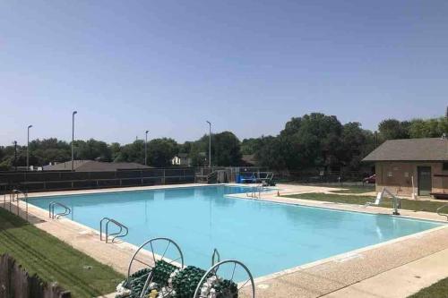 a large blue swimming pool in a park at CYC Eclectic Back House with BBQ Gazebo in San Antonio