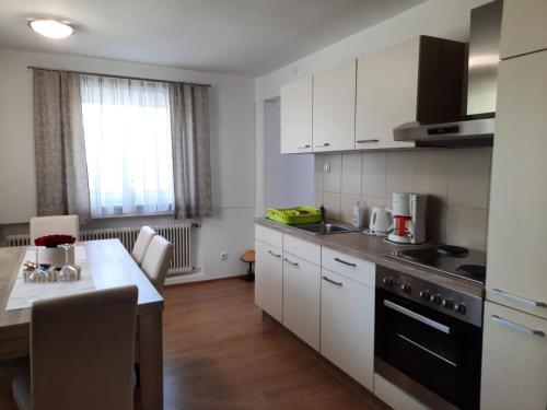 a kitchen with white cabinets and a black stove top oven at Bergblick in Golling an der Salzach