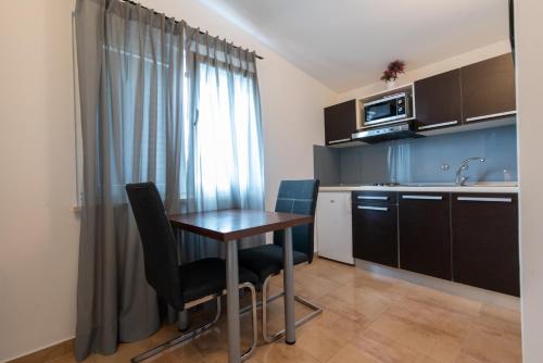 a kitchen with a table and chairs in a room at Apartments Amigos in Podstrana