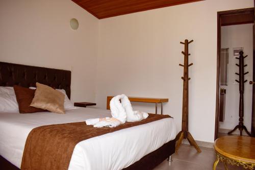 a bedroom with a bed with two towels on it at Posada Tierra Viva in Villa de Leyva