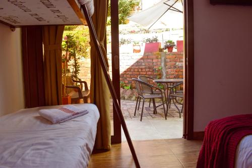 a bedroom with a bed and a patio with a table at Posada Tierra Viva in Villa de Leyva