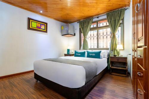 a bedroom with a large bed and a window at Ayenda Casa Candilejas in Bogotá