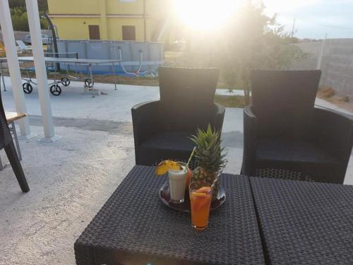 a table with a drink and a pineapple on it at Apartment Stanko in Ližnjan