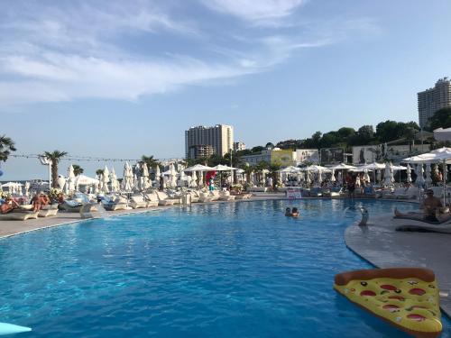 a swimming pool with chairs and people in a resort at Санрайз in Odesa