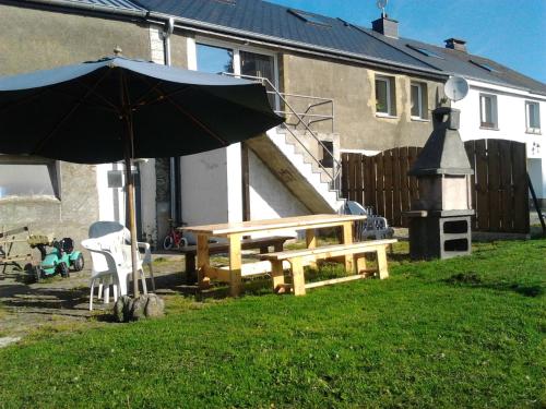 a picnic table and an umbrella in a yard at Gîte BELLA in Ebly