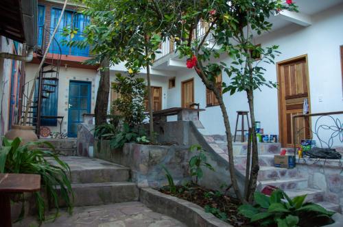 a house with stairs and trees in front of it at Chapada Backpackers Hostel Agência in Lençóis