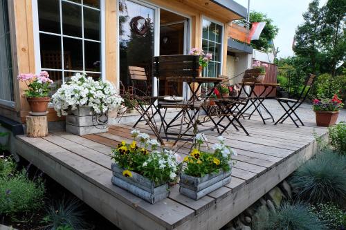 a wooden deck with flowers in pots on a house at Willa Pod Aniołem - Pokoje Gościnne & Apartamenty z widokiem na góry in Szczyrk