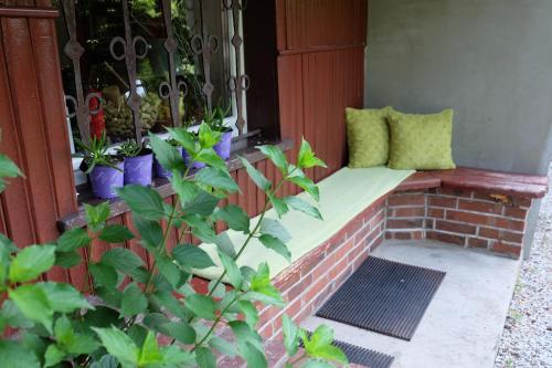 a porch bench with two pillows on it at Willa Pod Aniołem - Pokoje Gościnne & Apartamenty z widokiem na góry in Szczyrk