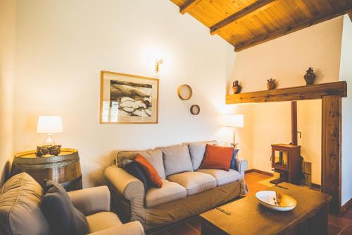 un soggiorno con un divano e un tavolo di MONTE DA RAPOSINHA Enoturismo, Montargil a Montargil