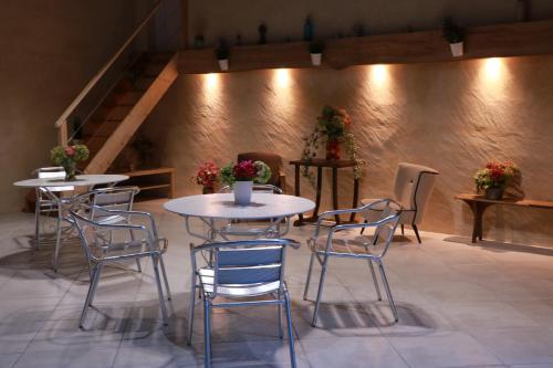 a group of tables and chairs in a room with stairs at Chambre familiale 5 personnes in Rouffignac