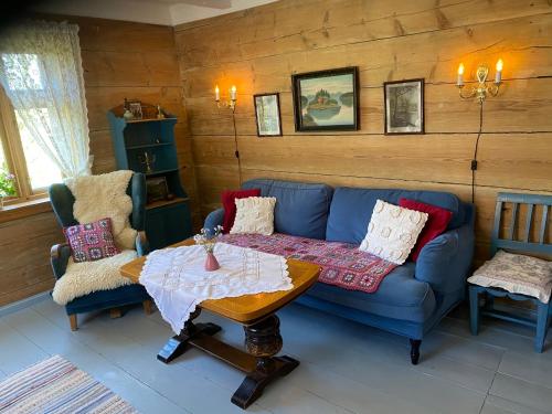 a living room with a blue couch and a table at Skjerping gård in Lonevåg