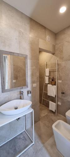 a bathroom with a sink and a toilet and a mirror at CORALLI DEL PLEMMIRIO in Syracuse