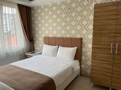 1 dormitorio con cama y pared en Bursa Malkoc Hotel en Bursa