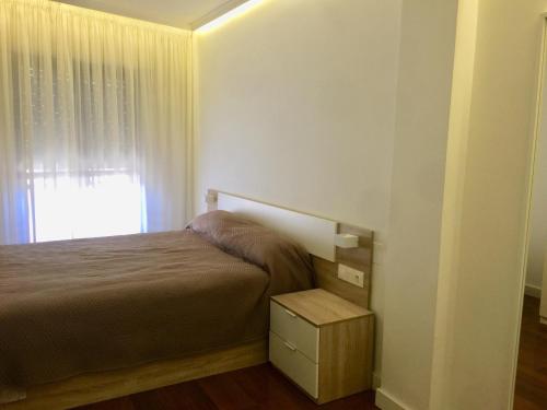 um pequeno quarto com uma cama e uma janela em Piso Plaza del ayuntamiento em Ponferrada