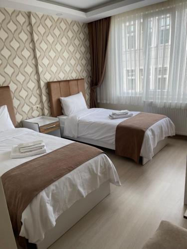 a hotel room with two beds and a window at Bursa Malkoc Hotel in Bursa