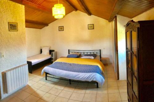 a bedroom with a bed and a couch in a room at Gîte du Mas in Saint-Privat-de-Champclos