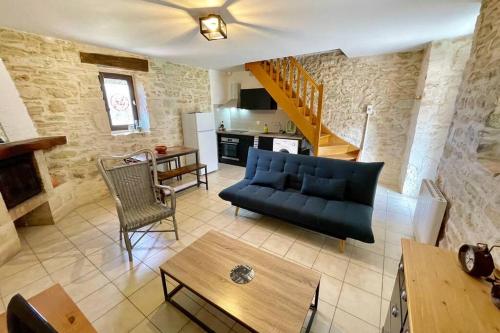 un salon avec un canapé bleu et une table dans l'établissement Gîte du Mas Champêtre, à Saint-Privat-de-Champclos