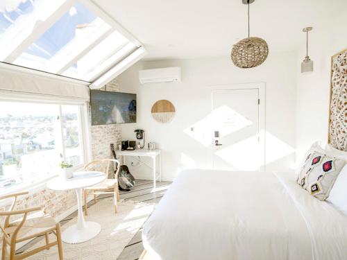 a bedroom with a white bed and a table and chairs at Venice V Hotel in Los Angeles
