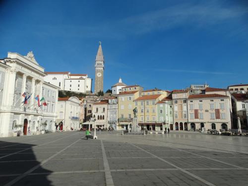 a city street with a clock tower in the background at Ellipse apartment in Piran