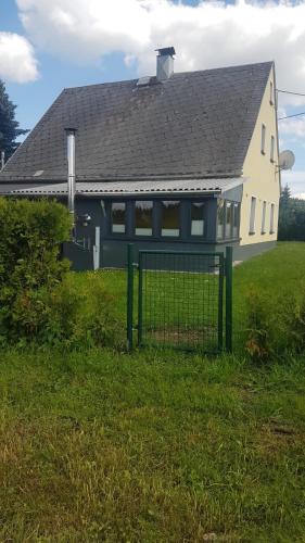 a house with a fence in front of it at Ferienhaus Kühnhaide im Erzgebirge in Kühnhaide