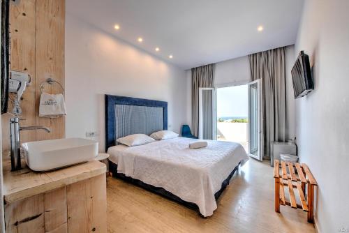 1 dormitorio con cama, bañera y lavamanos en Anamar Santorini en Monolithos