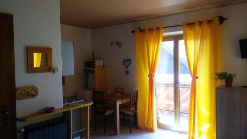 um quarto com uma porta de vidro deslizante com cortinas amarelas em Huatscher em Camporosso in Valcanale
