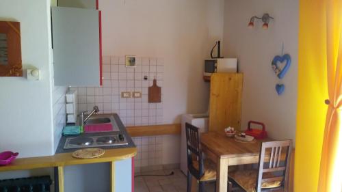 uma pequena cozinha com um lavatório e um fogão em Huatscher em Camporosso in Valcanale