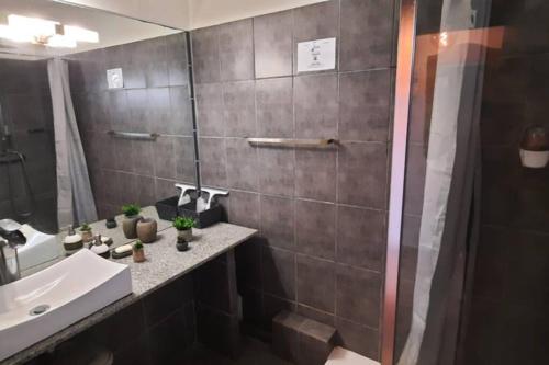 une salle de bain avec un lavabo et un miroir dans l'établissement LES EAUX BLEUES, au Gosier