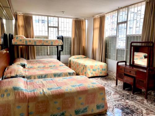 1 dormitorio con 2 camas, vestidor y ventanas en Hotel Ecoinn en Bogotá