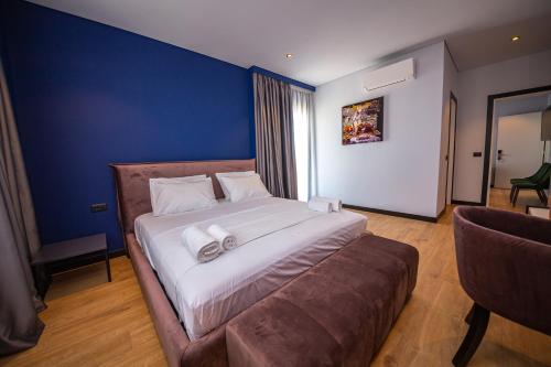 a bedroom with a large bed and a couch at Apart-Hotel Lili2 in Sarandë