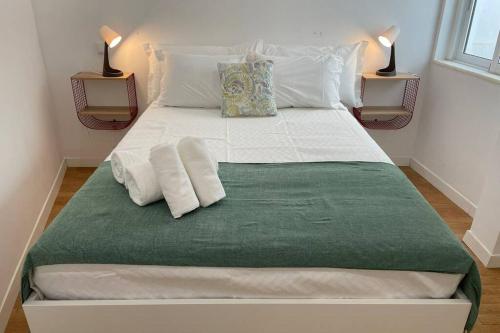 Una cama blanca grande con dos almohadas encima. en Janelas Verdes 37, en Faro