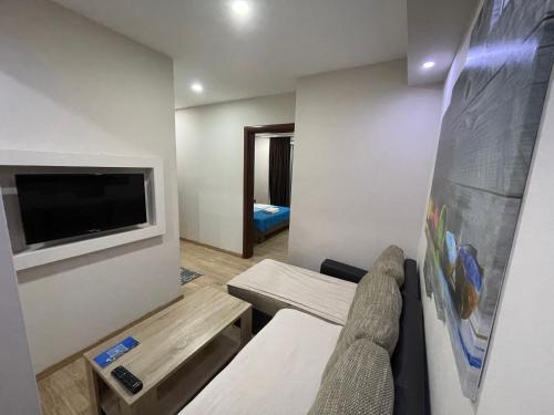 Habitación pequeña con sofá y TV. en Apartments Lati, en Ulcinj