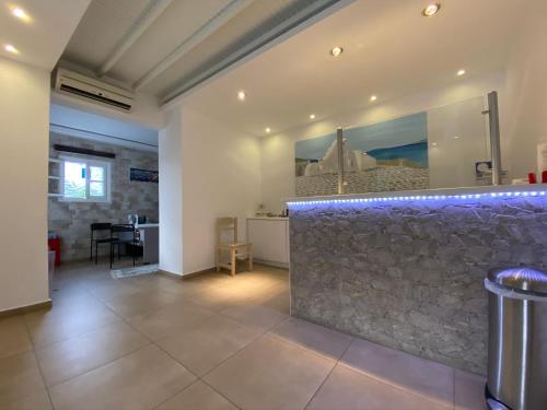 eine Bar mit einer Steinwand in einem Raum in der Unterkunft Anemos Hotel & Apartments in Ornos