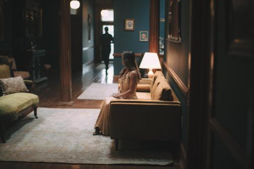 a woman sitting on a couch in a living room at The Grand Hotel in Hogansville