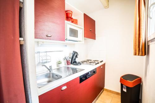 una pequeña cocina con fregadero y microondas en JASSE CAMARGUAISE 424 - CLIM PISCINE FAMILLE GALLARGUES - TOP PROS SERVICESConciergerie en Gallargues-Le-Montueux