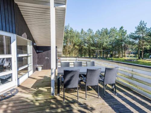 a patio with a table and chairs on a deck at Bright Cottage with Covered Terrace-By Traum in Nørre Nebel