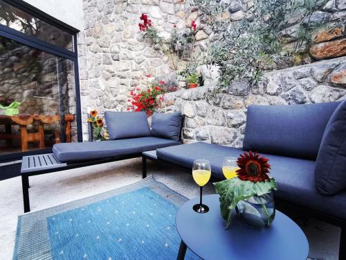 a patio with couches and a table with wine glasses at Apartments Sandra in Lovran