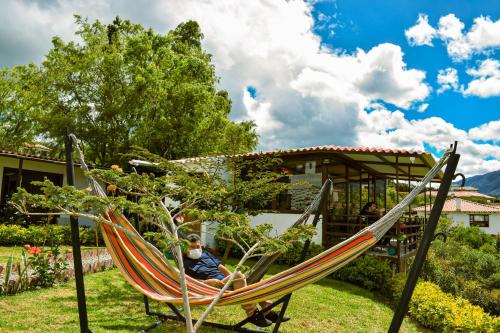 a person sitting in a hammock in a yard at Posada Tierra Viva in Villa de Leyva