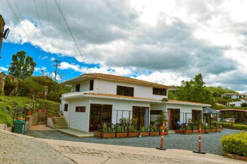 una pequeña casa blanca en un camino de grava en Posada Tierra Viva en Villa de Leyva