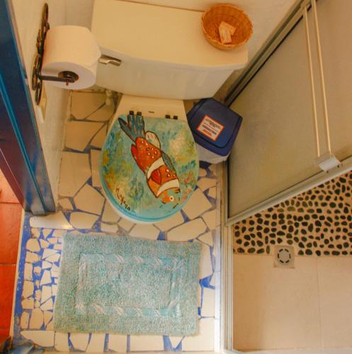 a toilet seat with a fish painted on it in a bathroom at Casa Encuentro Ecolodge, Outdoor Gym and Yoga in Guatapé