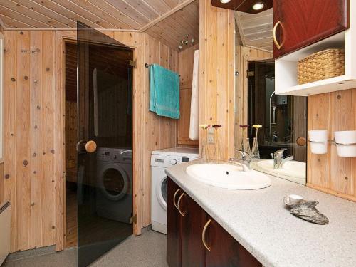 y baño con lavabo y lavadora. en Three-Bedroom Holiday home in Sæby 4, en Nordost