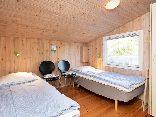 Habitación con 2 camas y 2 sillas. en Three-Bedroom Holiday home in Sæby 4, en Nordost