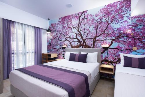 a bedroom with a purple tree mural on the wall at Monemvasia Green Apartments in Monemvasia