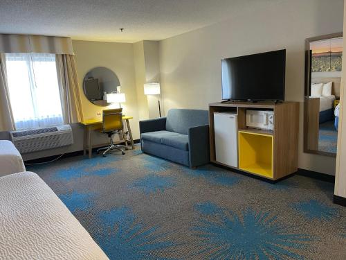 a hotel room with a bed and a tv and a couch at Days Inn by Wyndham Colby in Colby