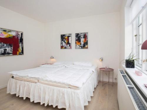 ein weißes Schlafzimmer mit einem großen weißen Bett. in der Unterkunft 6 person holiday home in L kken in Løkken