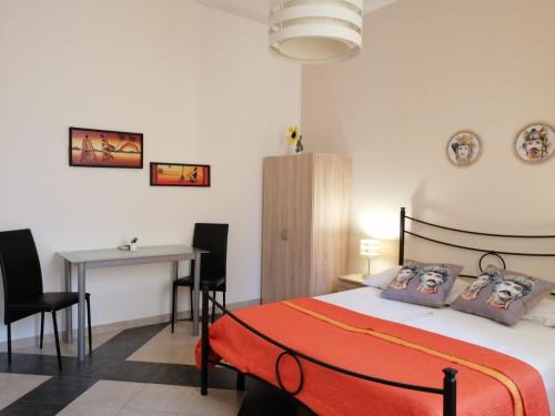1 dormitorio con 1 cama, mesa y sillas en b & b Jasmine, en Santa Teresa di Riva