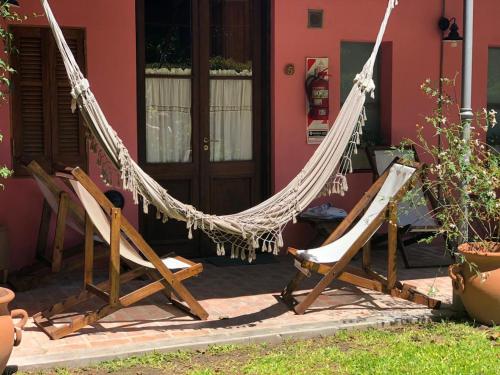 two chairs and a hammock in front of a house at Como Entonces Posada in Uribelarrea