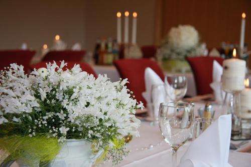 a white vase with white flowers on a table at Alver Hotel in Alversund